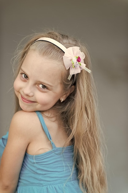 Small baby girl with smiling face in blue dress outdoor