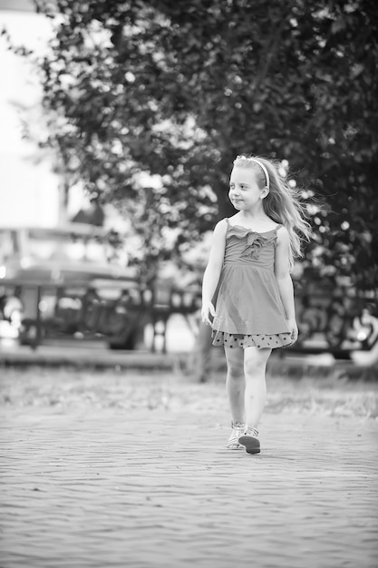 Small baby girl with smiling face in blue dress outdoor