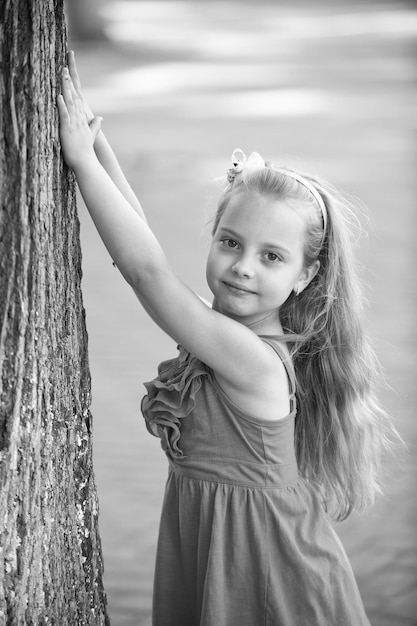 Small baby girl with smiling face in blue dress outdoor