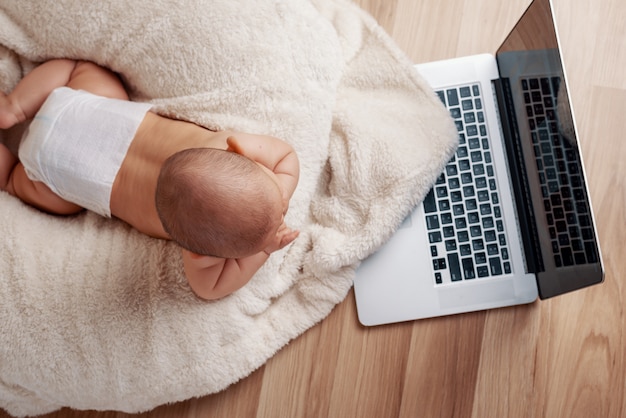 Small baby infant working playing learning on the laptop