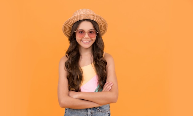 Small beauty child wear straw hat and glasses cheerful little girl on orange background