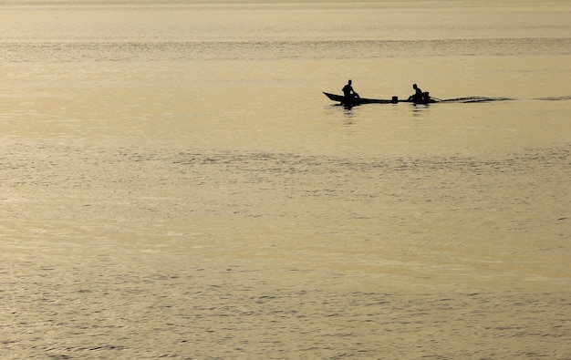 Small boat of residents of the Amazon region of Brazil sailing the river at sunset