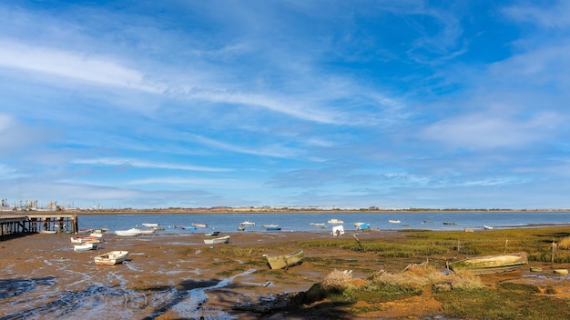 Small boats stranded on the shore of the coast in Huelva Spain