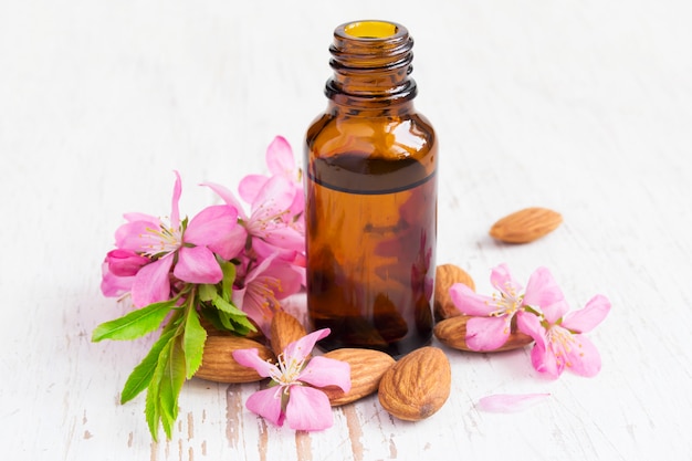 Small bottle of almond oil, almonds and flowers