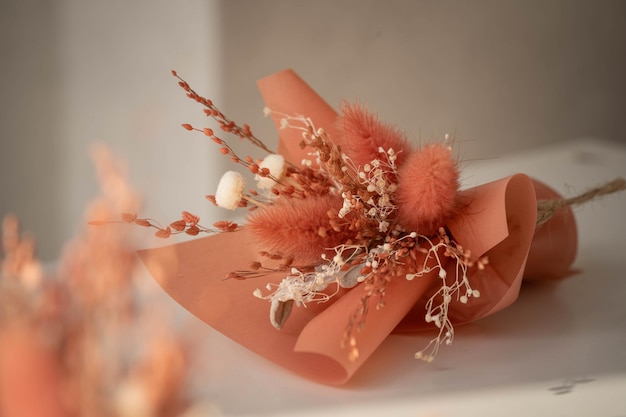 Small bouquet of dried flowers on a black background in terracotta colors incredible art