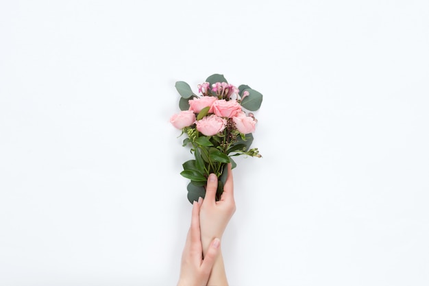 Small bouquet of pink bush roses in a woman's hand