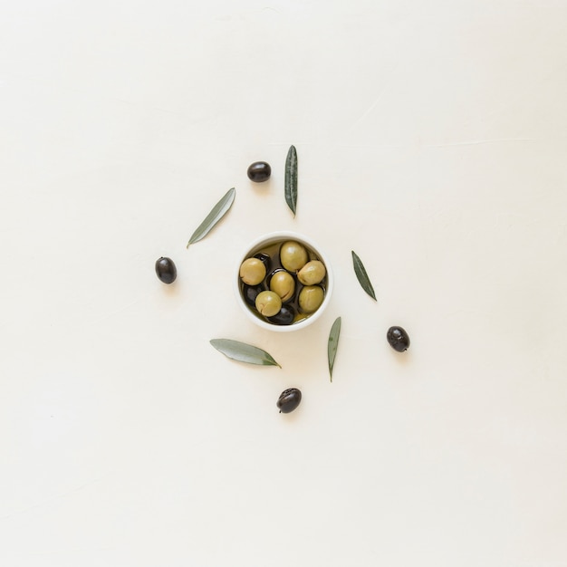 Photo small bowl with olives and leaves