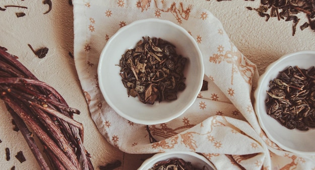 Small bowls with dried healing green tea and herbs ritual purification and cleansing closeup