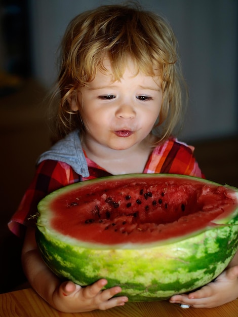 Small boy eating red watermelon