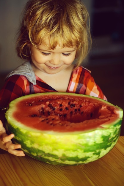 Small boy eating red watermelon