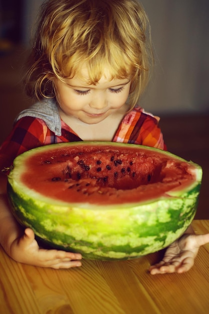 Small boy eating red watermelon