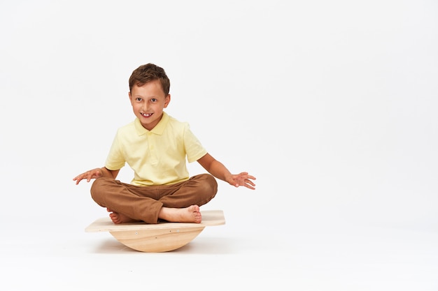 Small boy is sitting on a special simulator for training vestibular apparatus