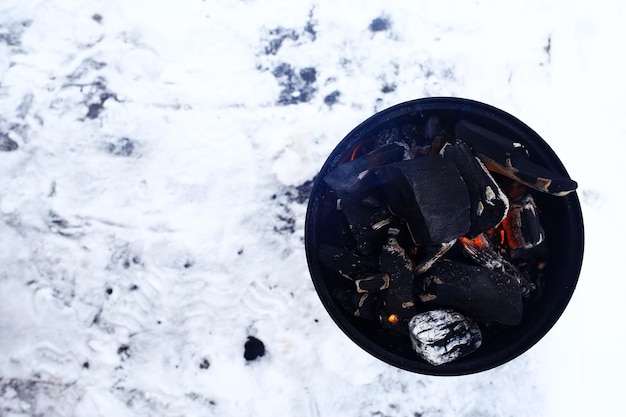 small brazier with coals in the snow in winter