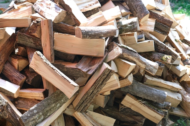 Small brown chopped firewood with grey bark pile lies