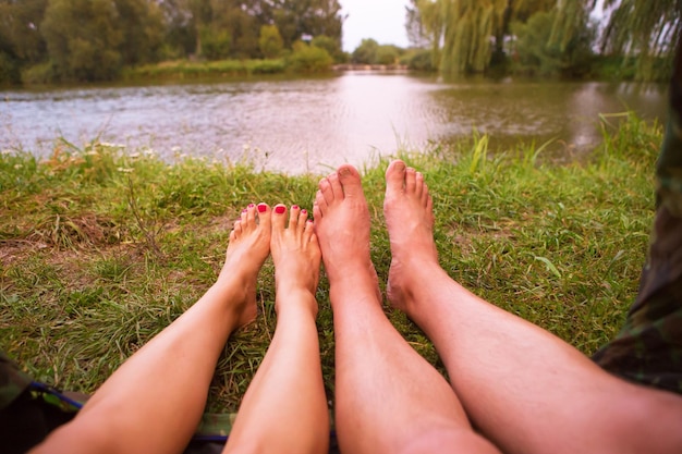 A small camping tent on the lake a night's lodging and the feet of a young couple