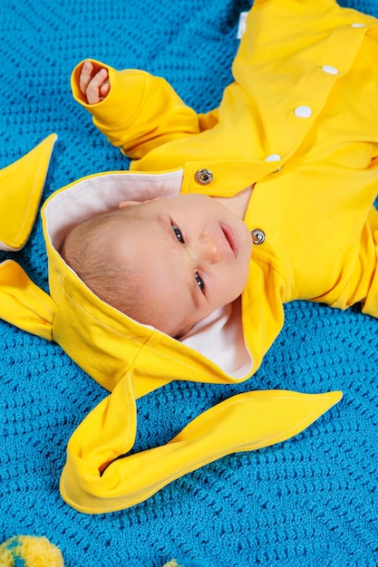 A small child 45 months old lies on a bed in yellow clothes The child begins to hold his head Baby clothes