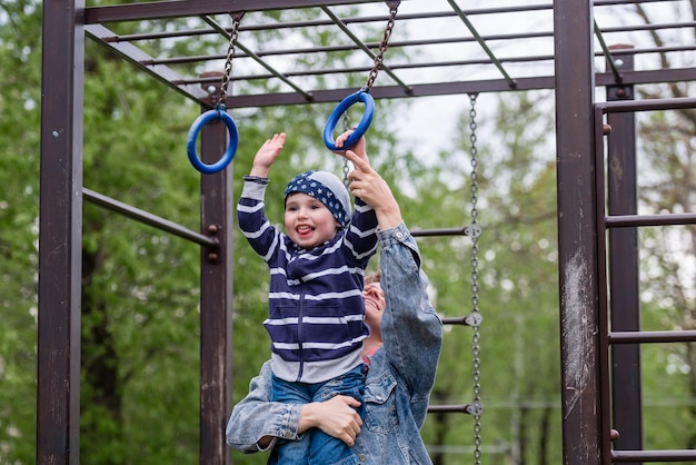 A small child boy and his mother on a children's playground