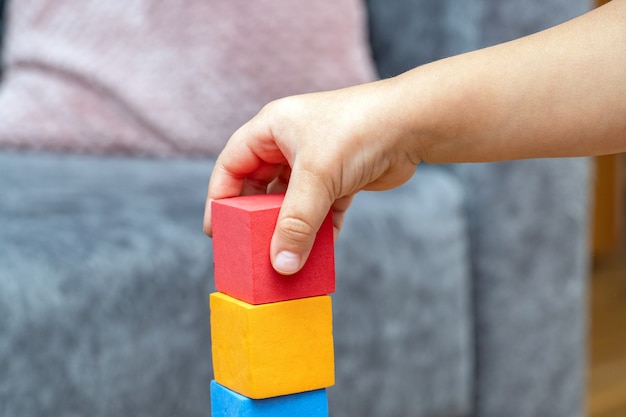 Small child boy plays with educational toy blocks of the constructor