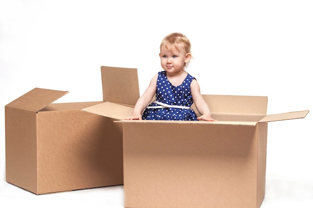 A small child in cardboard boxes on white surface