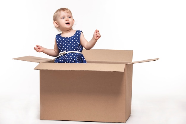 A small child in cardboard boxes on white surface