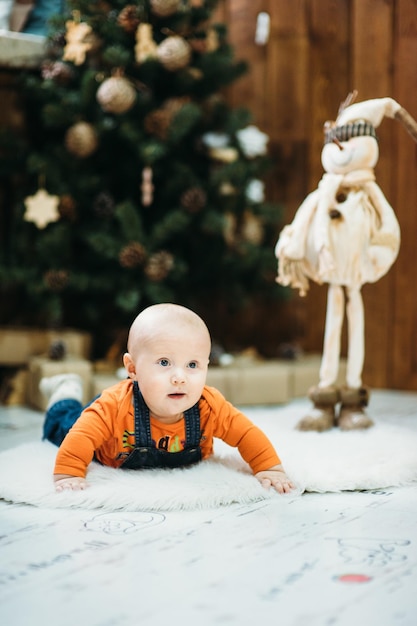 A small child in a denim blue overalls crawls