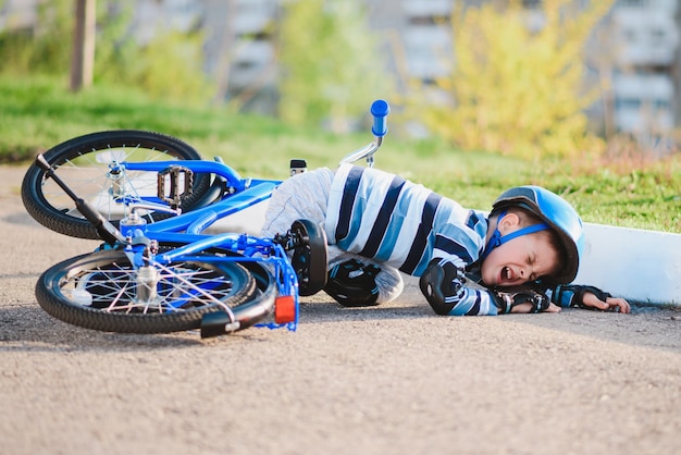 A small child fell from a bicycle onto the road, crying and screaming in pain.