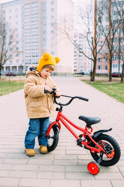 a small child learns to ride a bike for the first time in the city in spring