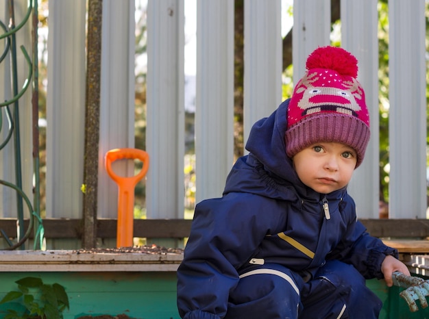 A small child plays in the sandbox on a sunny day