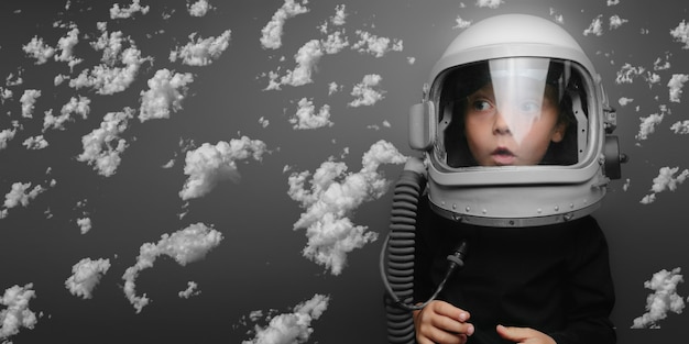 Small child wants to fly an airplane wearing an airplane helmet flying in the clouds