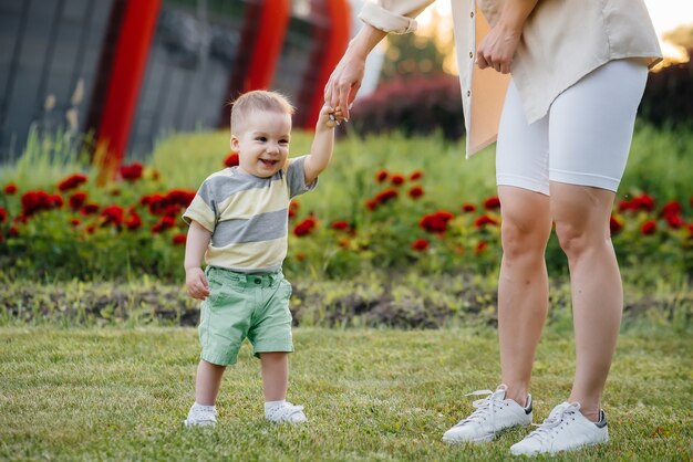 Small children are walking in the park with their parents.

