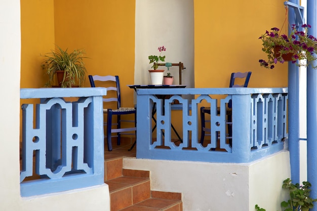 Small cozy balcony with table and chairs near the house entrance