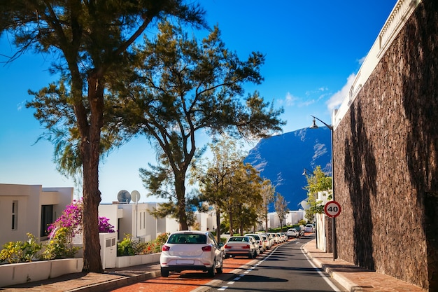 Small cozy street with parked cars in Los Gigantes residential area, Tenerife, Canary Islands, Spain