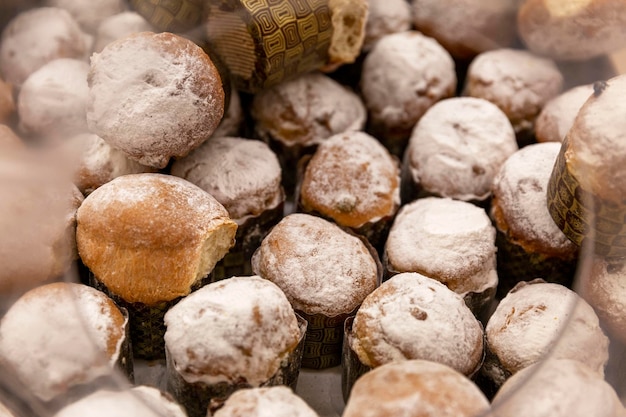 Small cupcakes with powdered sugar in a shop window Traditional pastry for Easter Closeup