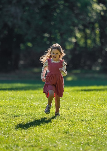 A small cute girl runs quickly Walk in the park Active lifestyle movement