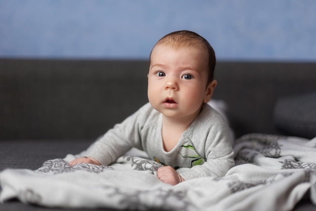 small cute serious baby carefully looks into the frame