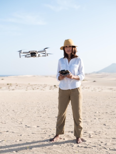 Small drone piloted by woman outdoors