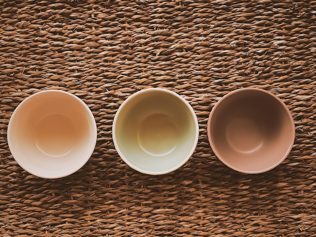 Small empty ceramic measure bowls on rustic wicker background food preparation flatlay and cooking design