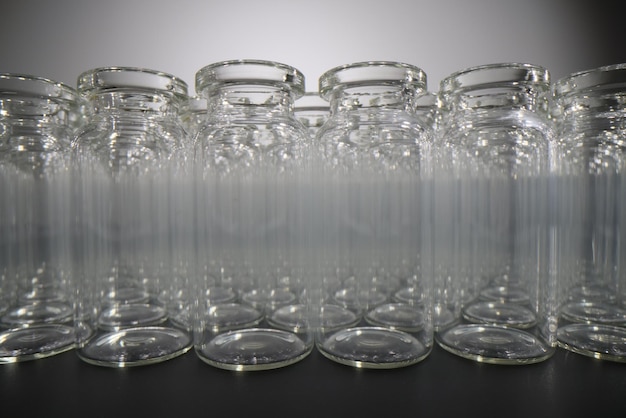 Small empty glass bottles on black table in laboratory