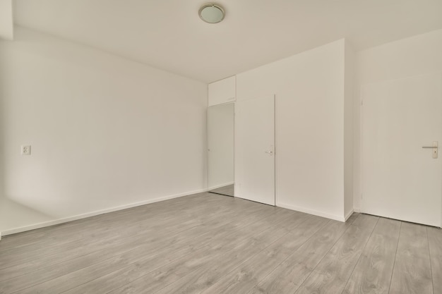 A small empty room with mirror and several doors outside in a modern house