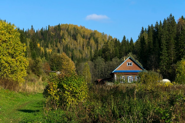 Small farm in a beautiful autumn valley among wooded hills