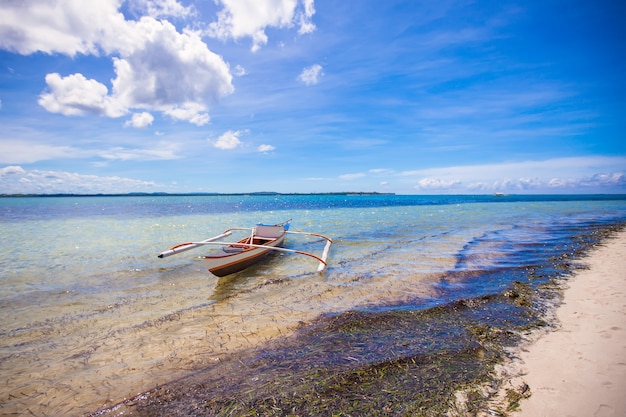 Small Fishing boat on the white tropical beach