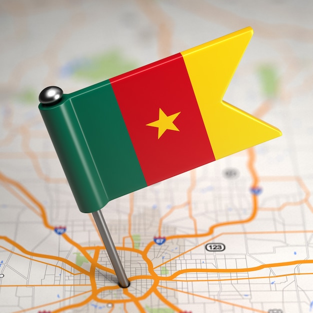 Photo small flag of cameroon on a map background with selective focus.