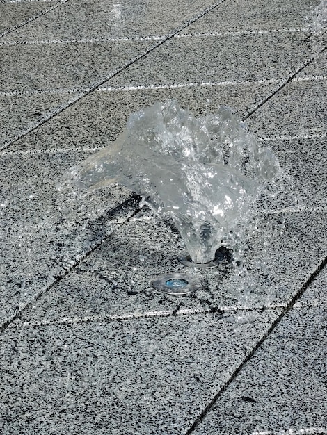 A small fountain on a marble gray surface on the street