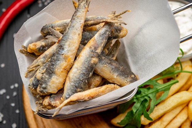 Small fried fish and french fries at an seaside restaurant Fried anchovies