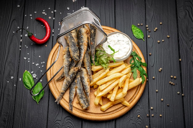 Small fried fish and french fries at an seaside restaurant Fried anchovies