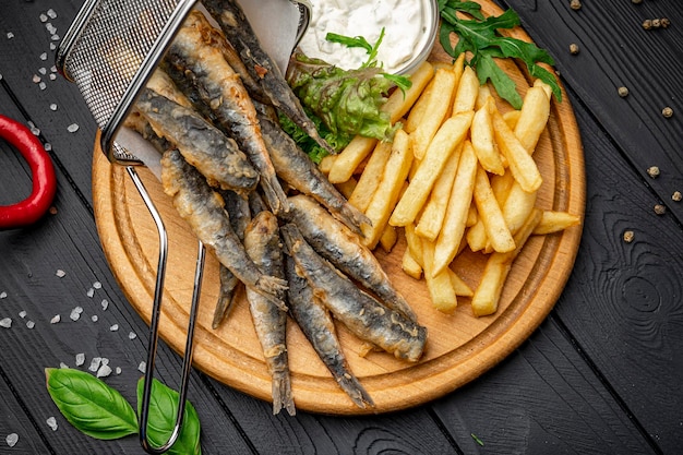 Small fried fish and french fries at an seaside restaurant Fried anchovies