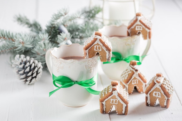 Small gingerbread cottages with sweet drink as Christmas snack