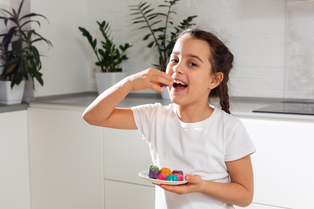 Small girl celebrating Holi Festival of Colors holding tray in hand.