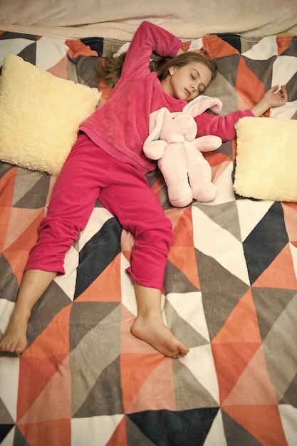 Small girl child ready to sleep Time to relax Childhood happiness Pajama party Good night Little happy girl in bedroom Good morning International childrens day What an interesting toy