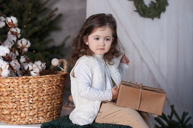 Small girl opens a gift on Christmas